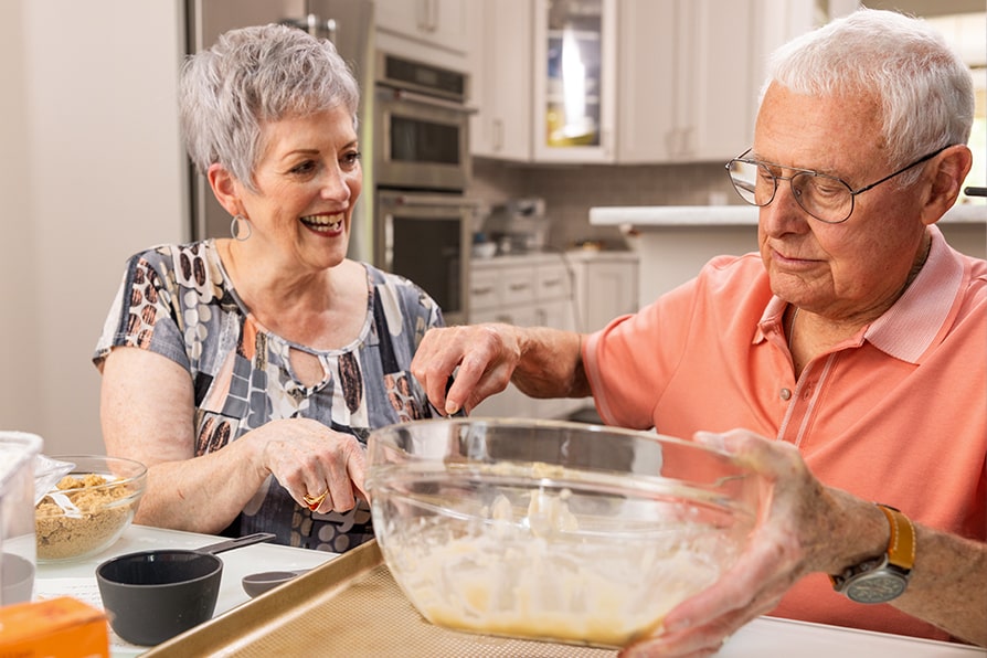 Margaret YESCARTA® (axicabtagene ciloleucel) patient ambassador baking with caregiver Skip.