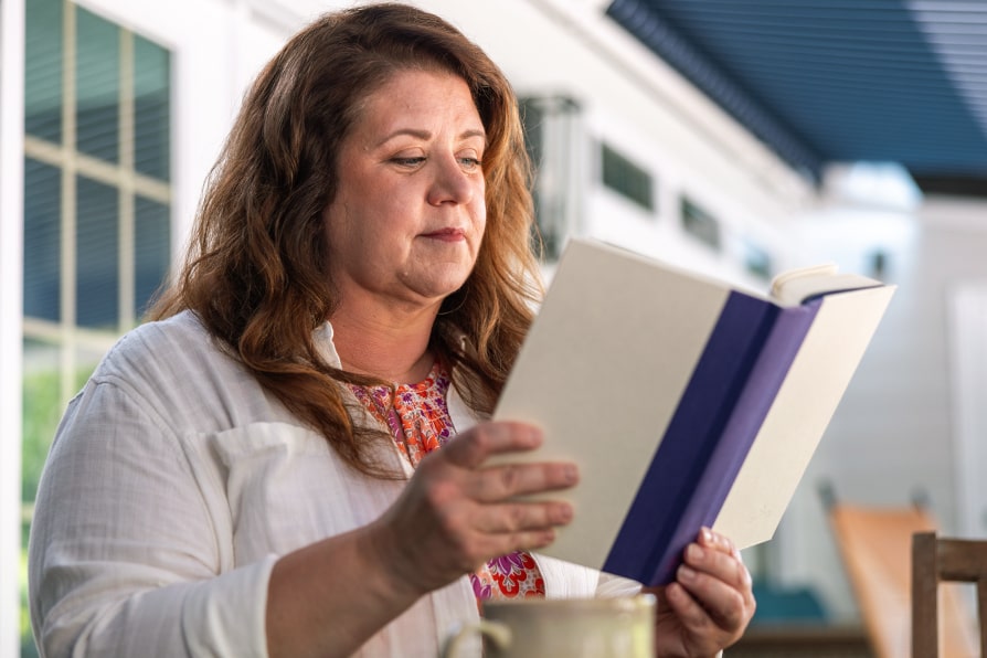 Nikki YESCARTA® (axicabtagene ciloleucel) patient ambassador reading a book.